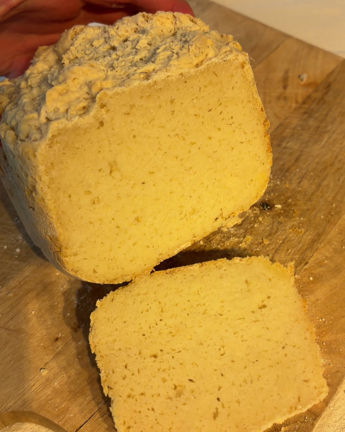 Glutenvrij brood uit de broodbakmachine, aangesneden op een houten plank