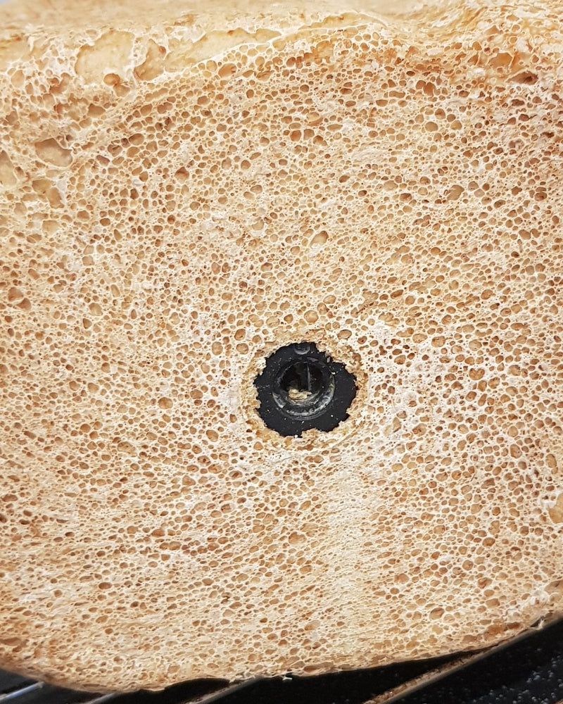 De kneedhaak zit na het bakken nog vast in de onderkant van het brood